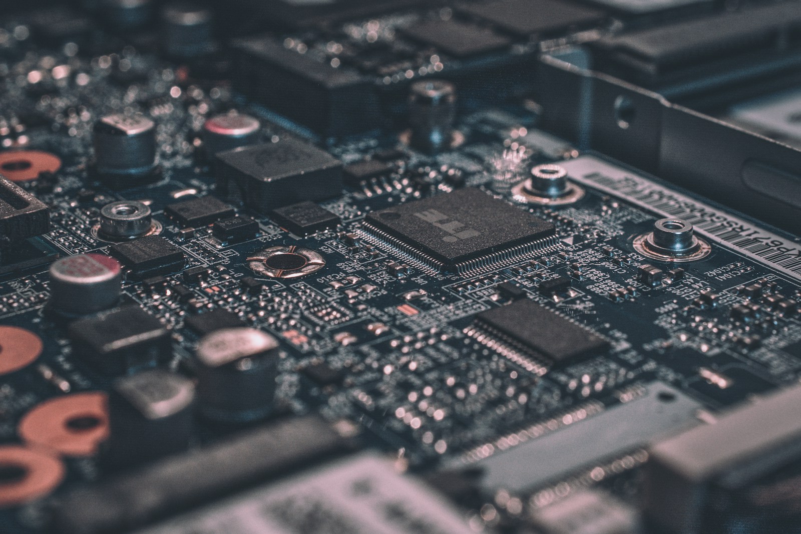 Macro view of a laptop circuit board with chips, traces, and mounting points.